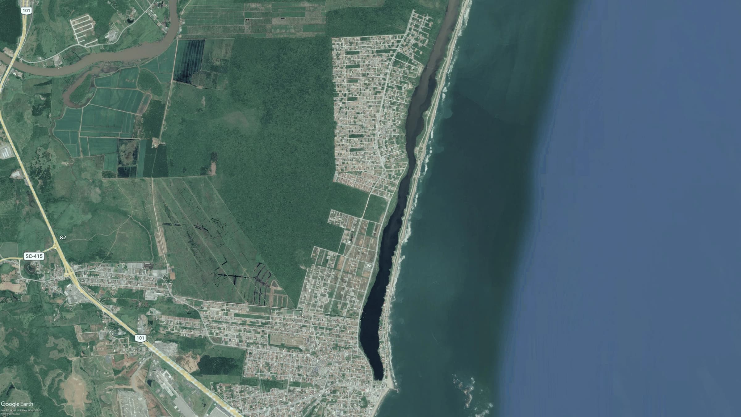 Vista aérea de Barra Velha com a lagoa, o centro e a praia.