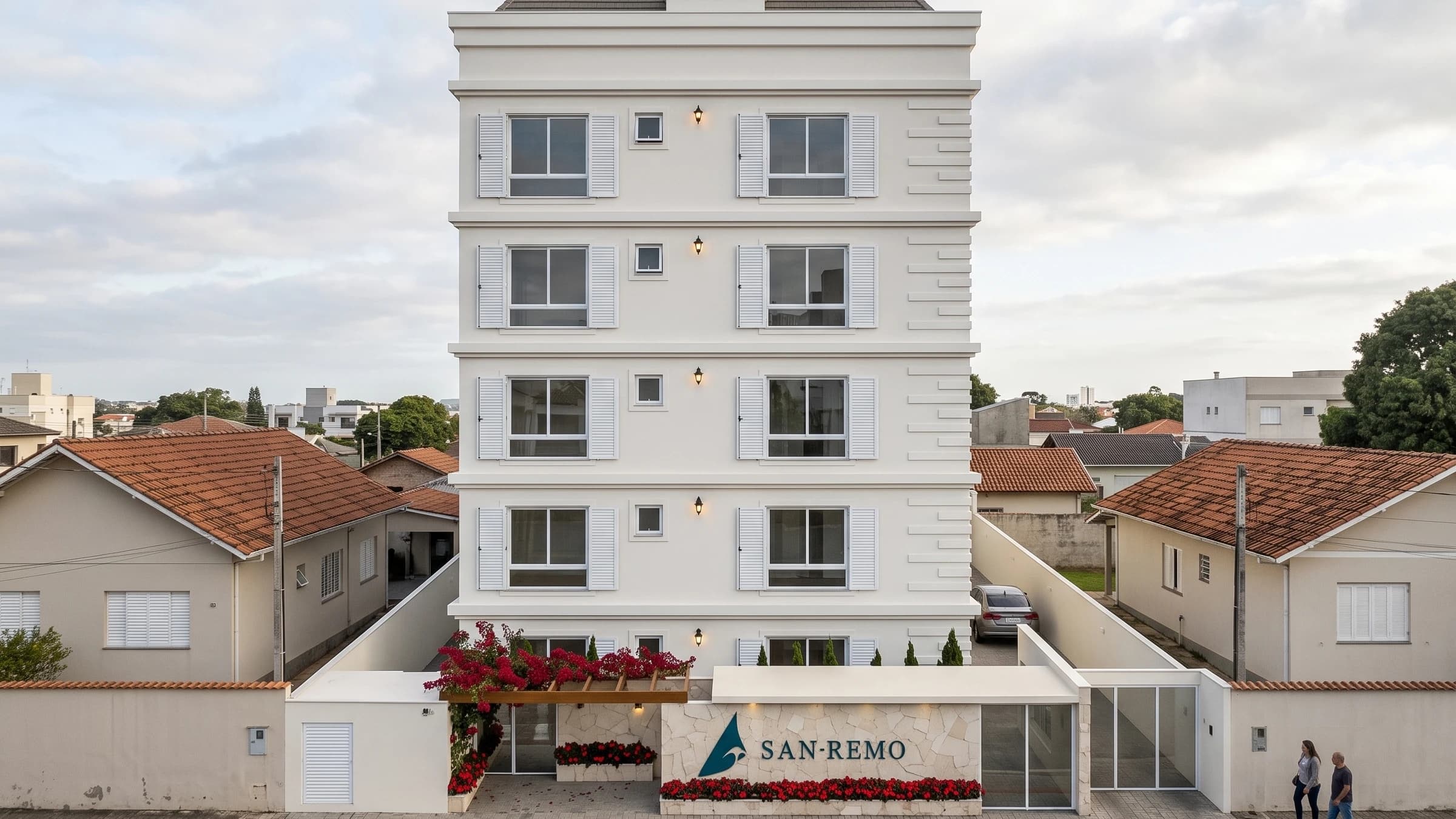 Fachada do San Remo de dia, com frontão, cornija, telhado aparente, venezianas e arandelas.